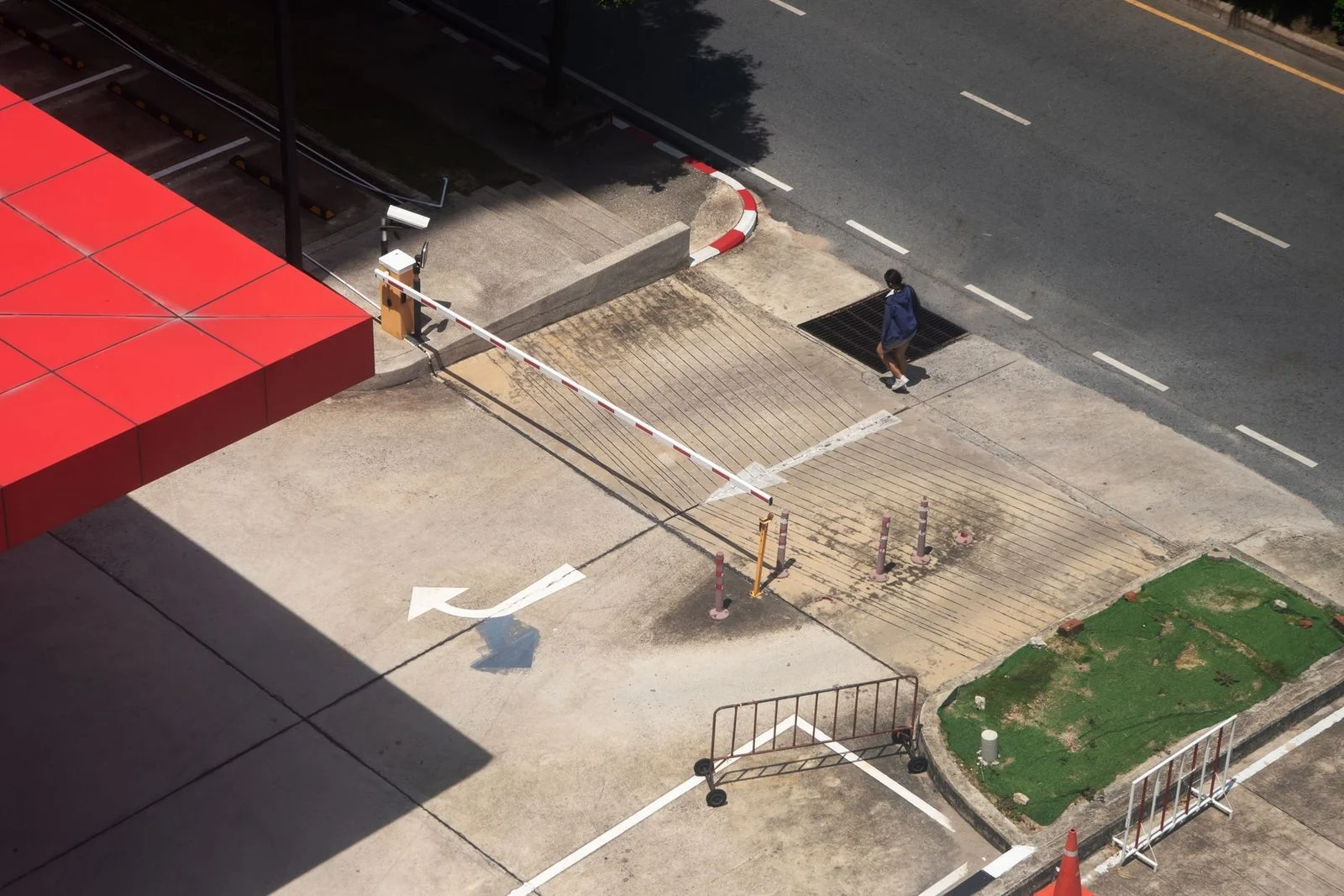 Aerial view of a busy city intersection with marked pedestrian crosswalks and roadside barriers.