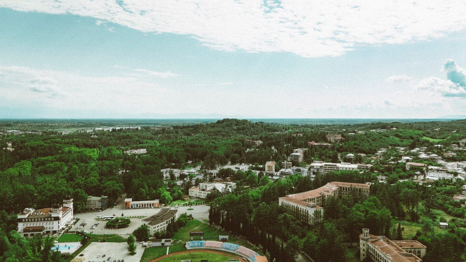 Aerial view of a green, tree-lined Georgia cityscape with buildings spread across the landscape.