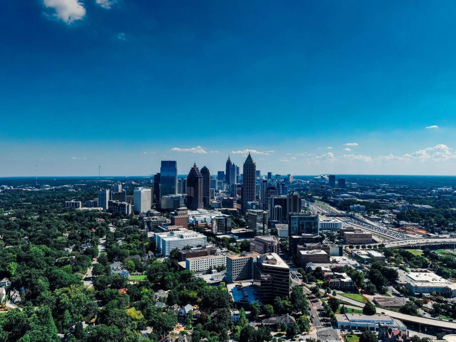 Aerial view of Atlanta's skyline under a clear blue sky.