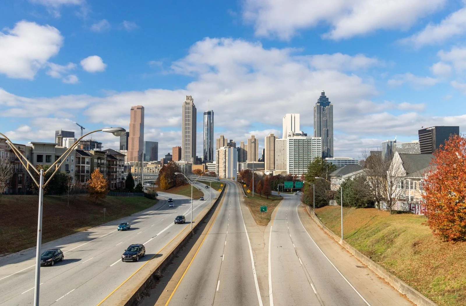 Aerial view of the Atlanta skyline with multi-lane highways leading into the city on a sunny day.