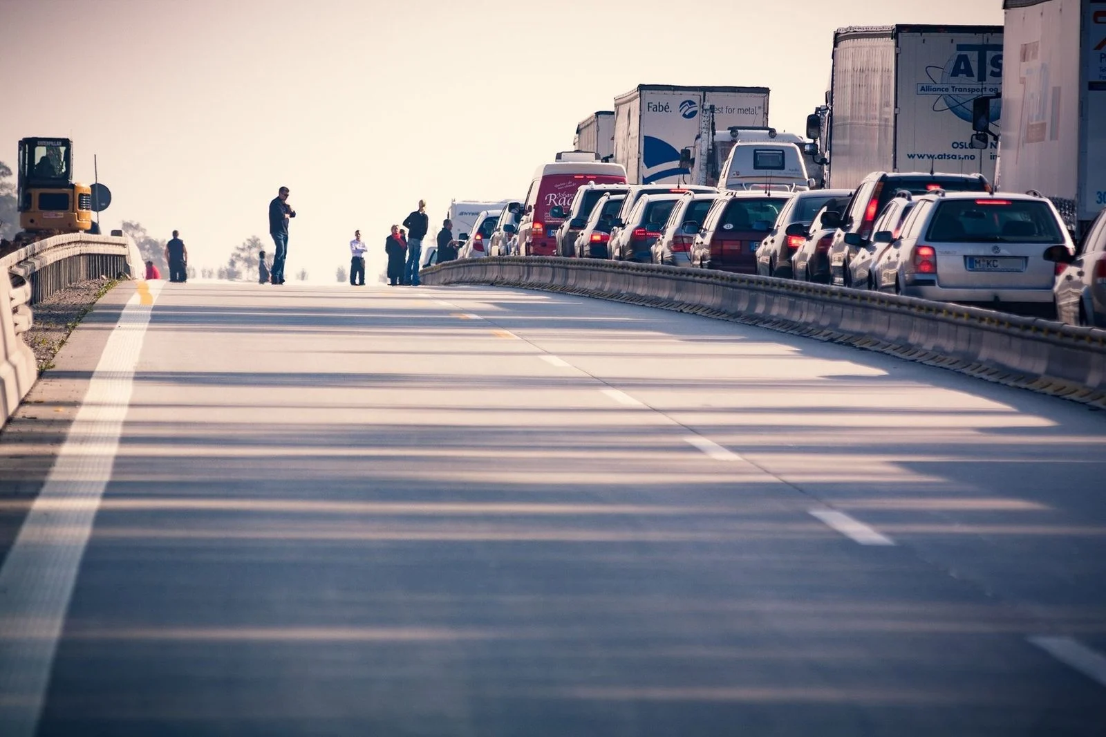 Cars and trucks stalled in a daytime highway traffic jam.