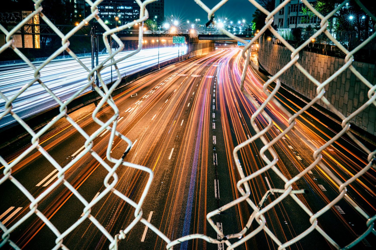 Long-exposure night view of busy Atlanta highway traffic with glowing city lights.