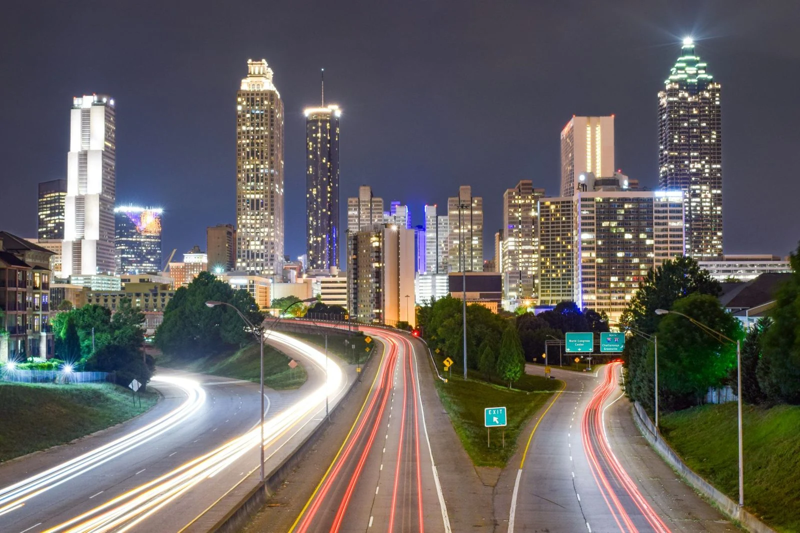 Vista nocturna del horizonte de Atlanta con estelas de luz sobre las calles concurridas de la ciudad.