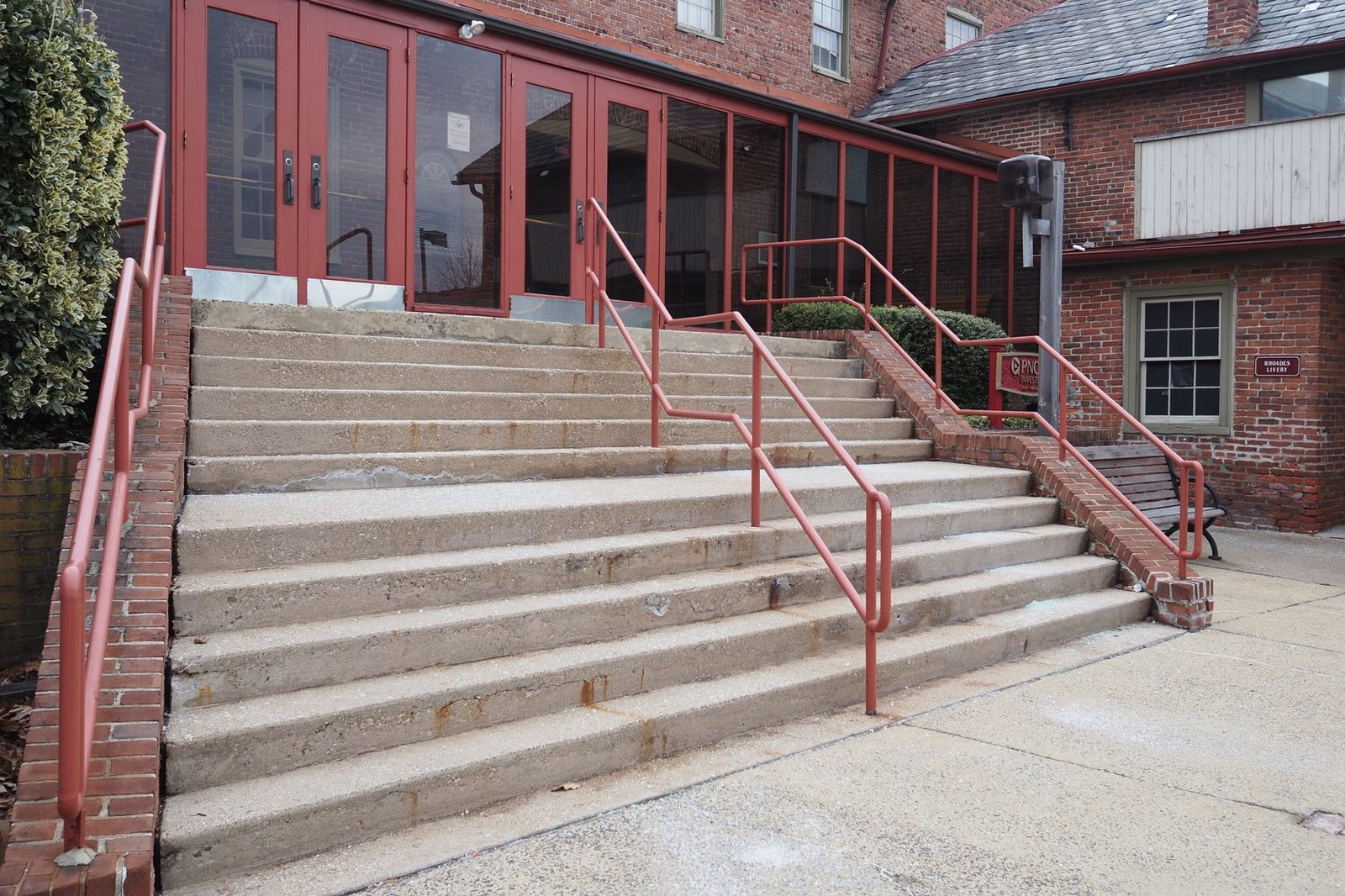 Red-brick building entrance with concrete steps and metal railings in Doylestown, Pennsylvania.